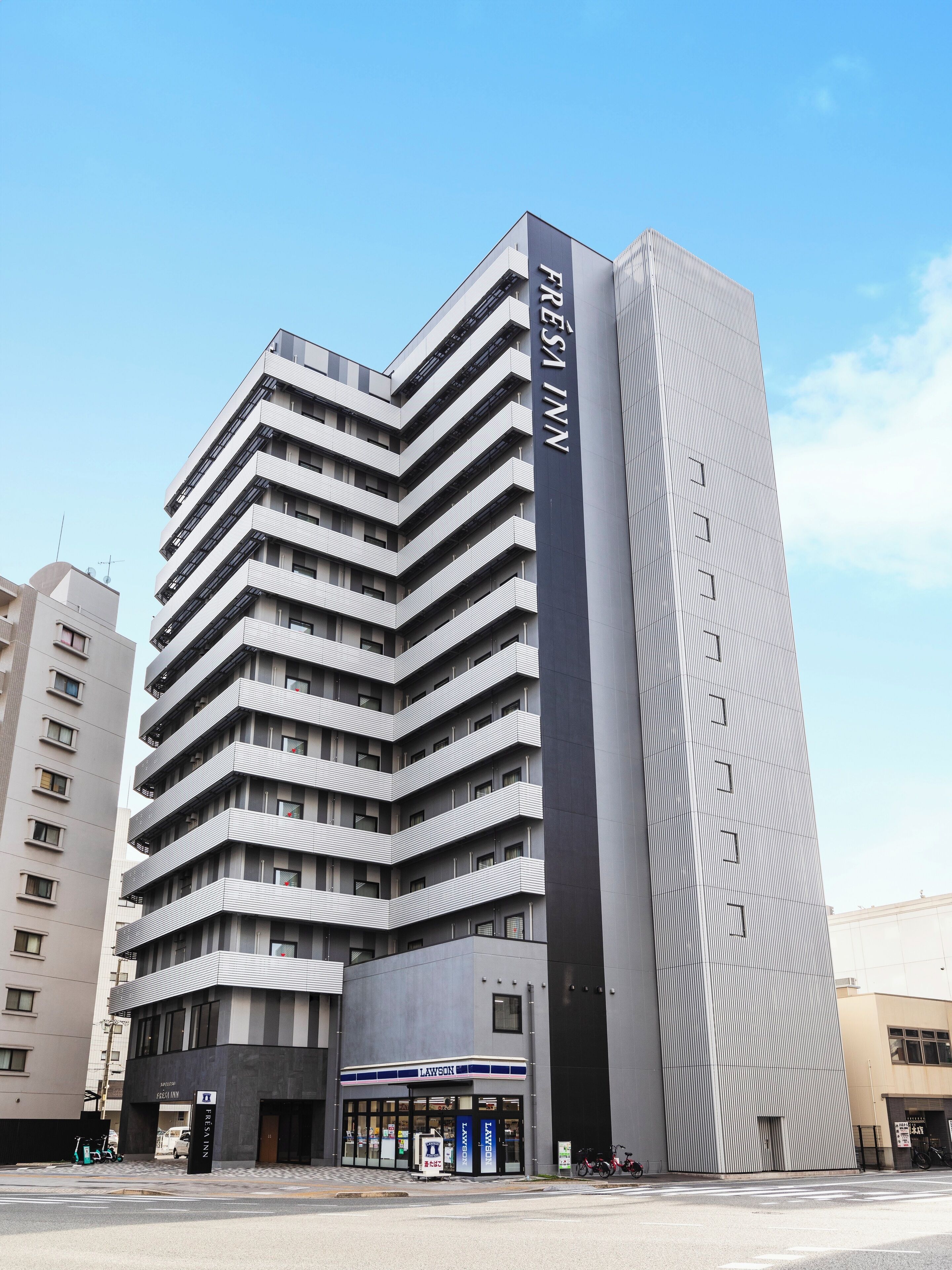 A multi-story hotel with a modern design, featuring a prominent 'FRESENI' sign on the facade.
