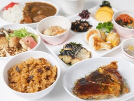 Una variedad de platos que incluyen arroz, pescado y verduras, lo que sugiere una amplia selección de comidas.