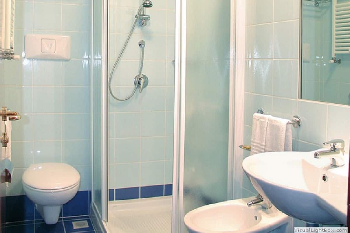 Une salle de bain avec une douche à parois de verre, des toilettes et un lavabo avec un miroir.