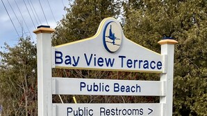 A sign for Bay View Terrace with directions to public beach, public restrooms, D.C. Adventure Center, and kayak rentals.