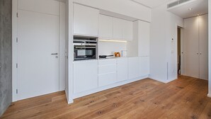 A modern kitchen with white cabinetry, a built-in oven, and a microwave. - Penthouse Dalias with private jacuzzi in Port de Pollensa (Puerto Pollensa)