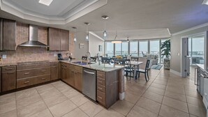 A modern kitchen with a large island, built-in appliances, and a dining area with a view. - DOWN BY THE BAY! ASK ABOUT DISCOUNTS! 3 Bedroom Unit Amazing bay views! (Orange Beach)