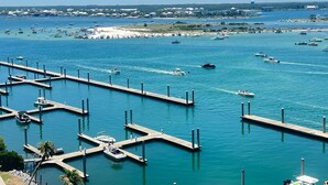 A marina with multiple docks and boats, surrounded by a coastal landscape with buildings in the background. - DOWN BY THE BAY! ASK ABOUT DISCOUNTS! 3 Bedroom Unit Amazing bay views! (Orange Beach)