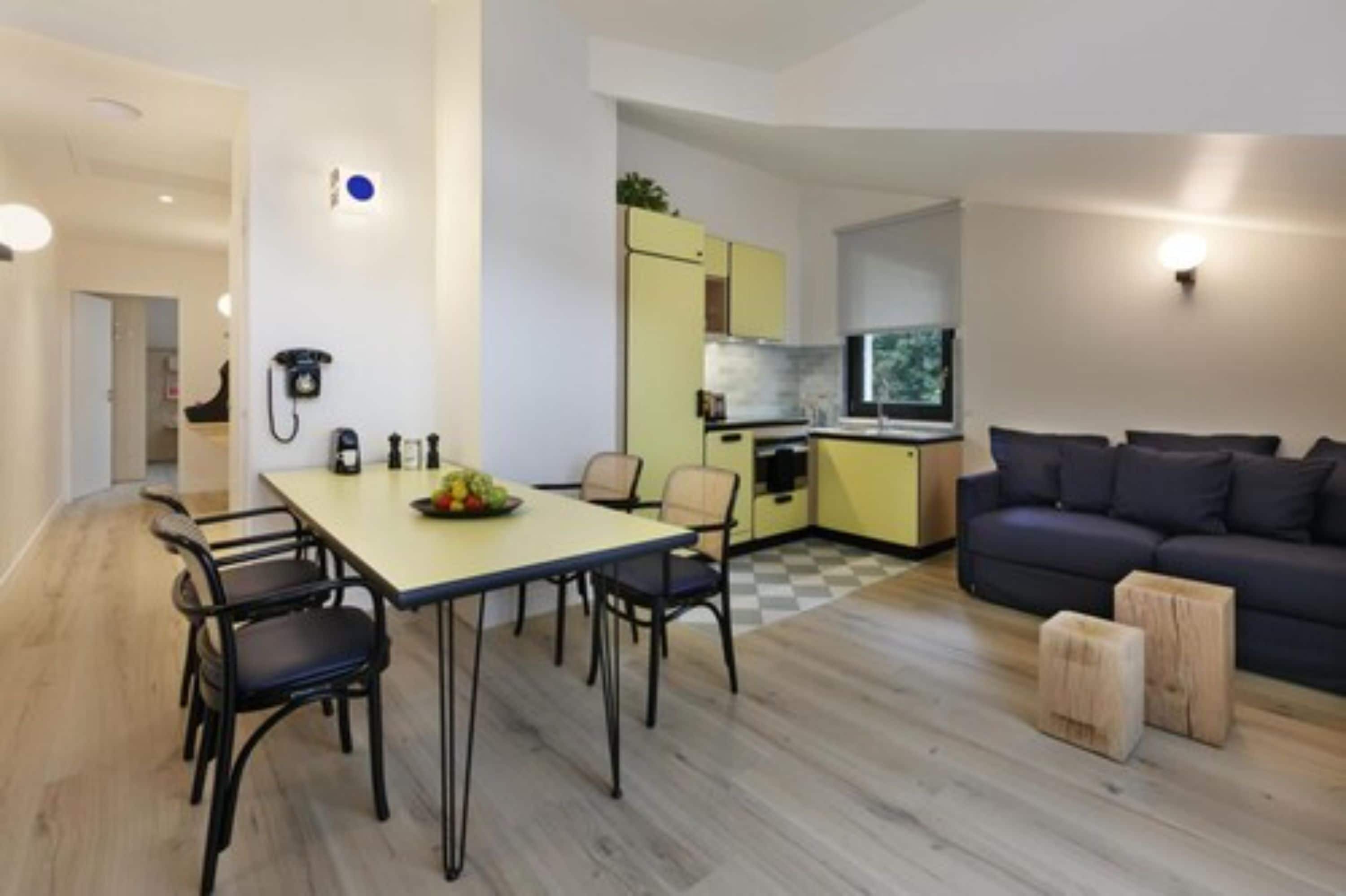 A compact living space with a dining area, kitchenette, and a sofa.