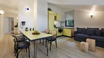 A compact living space with a dining area, kitchenette, and a sofa.
