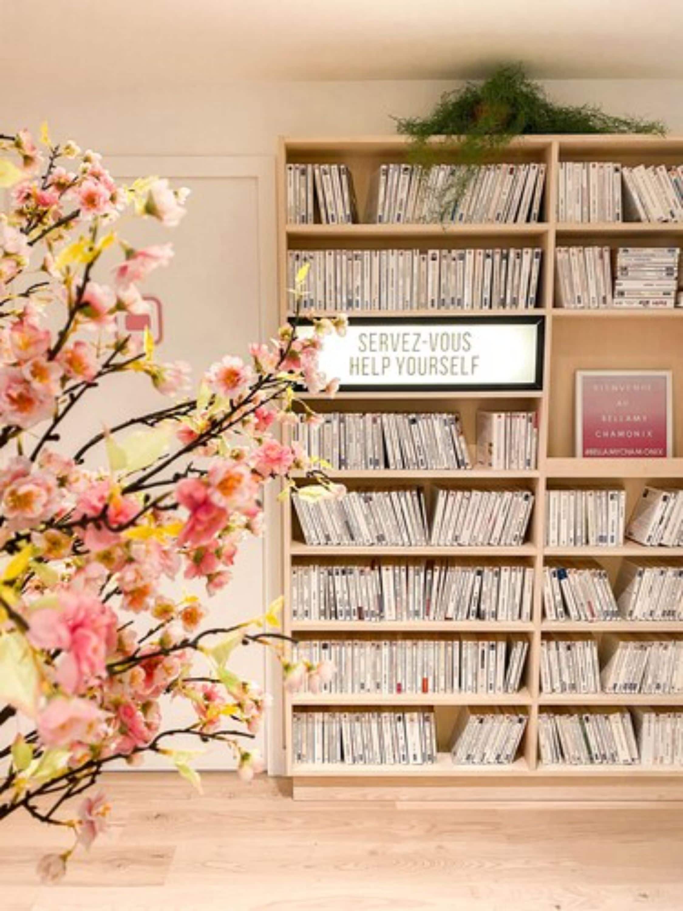 Una estantería llena de libros y un letrero que dice "SERVEZ-VOUS HELP YOURSELF".