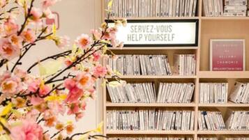 Una estantería llena de libros y un letrero que dice "SERVEZ-VOUS HELP YOURSELF".