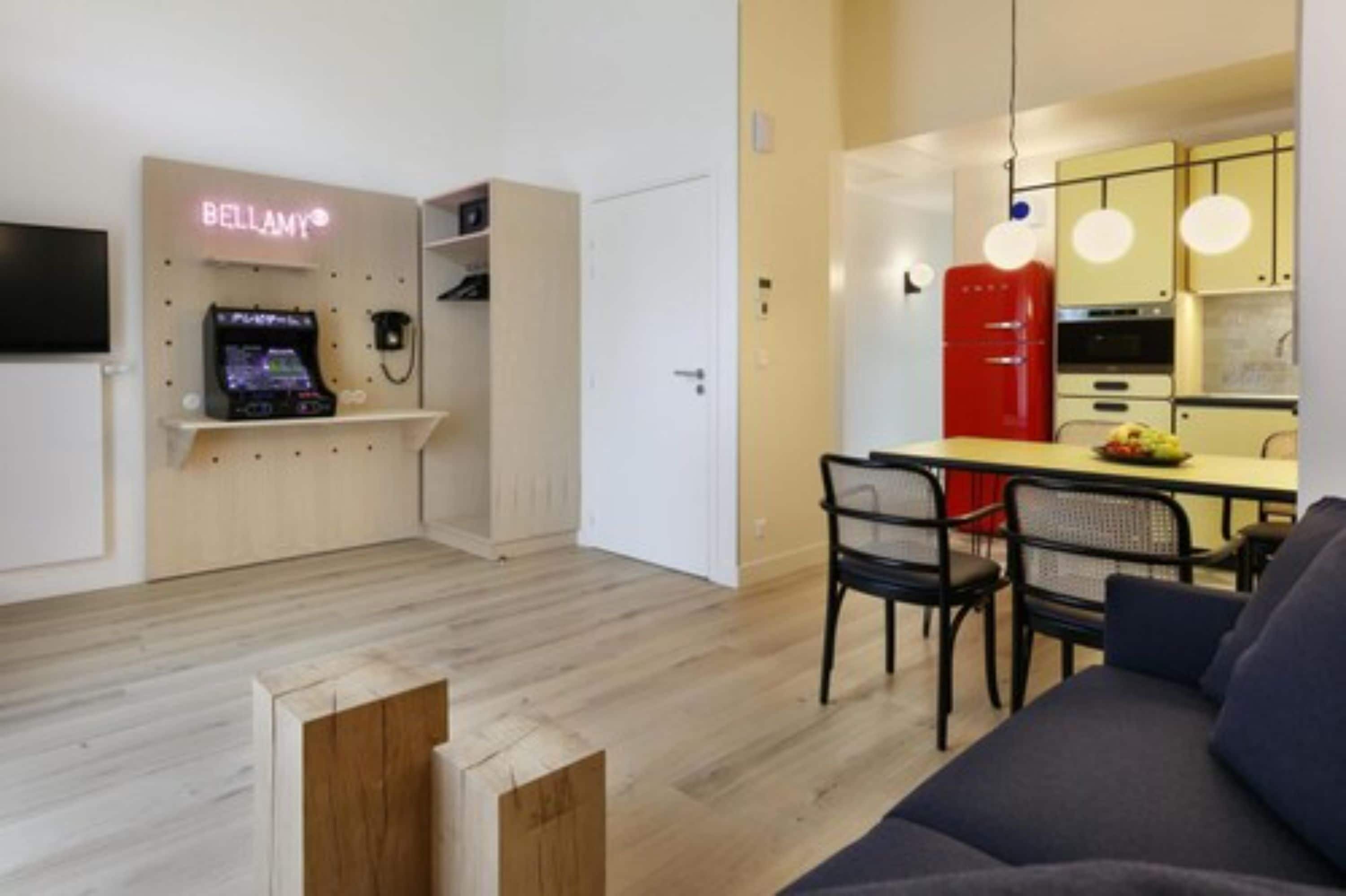 Een modern appartement met een eethoek, keuken en een gameconsole in de woonkamer.
