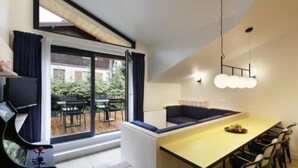 A modern kitchen with a dining area, large windows, and a view of the outdoors. - Appart'hôtel Bellamy Chamonix (Chamonix-Mont-Blanc)