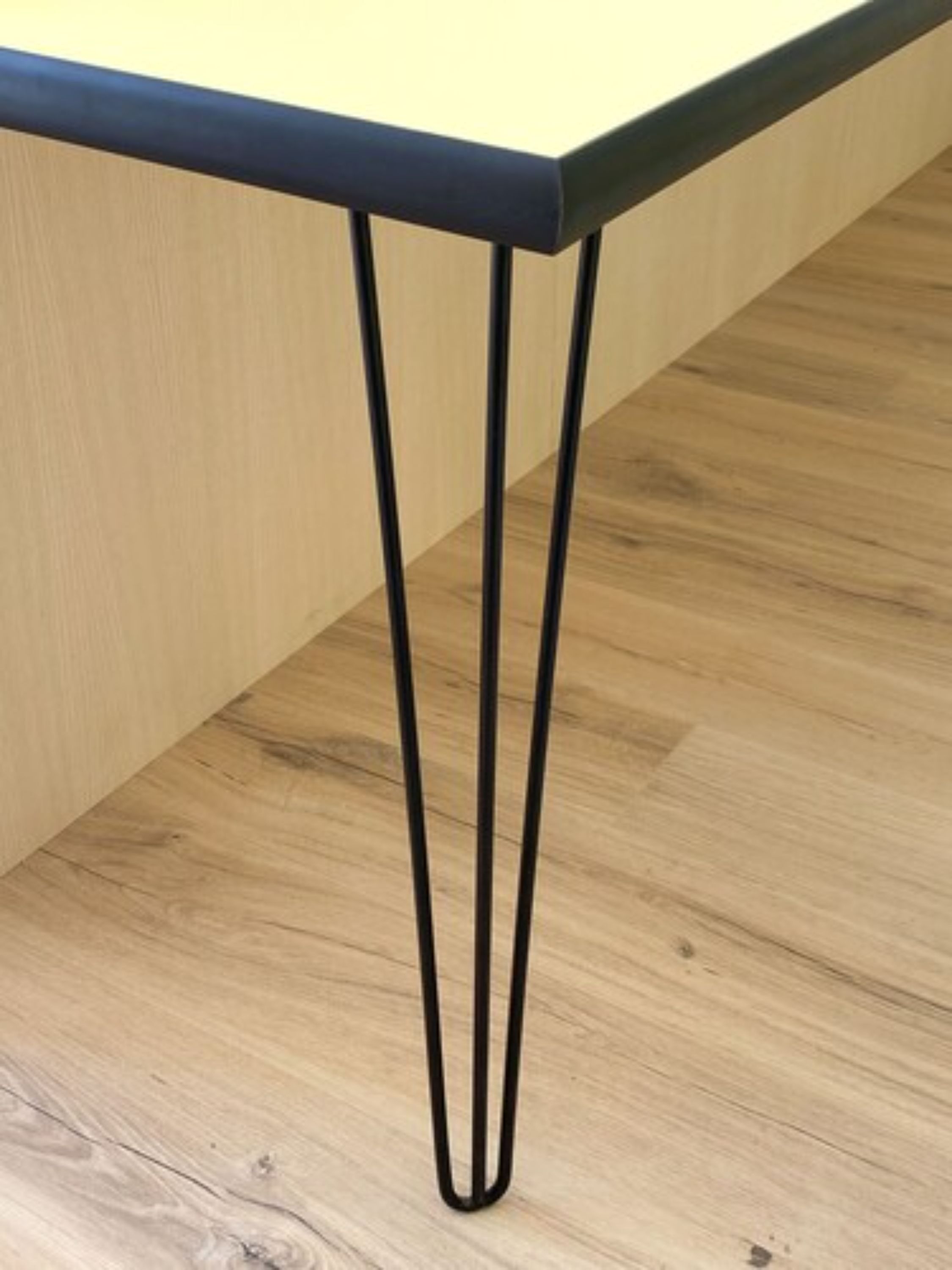 A table with a dark top and three black legs.