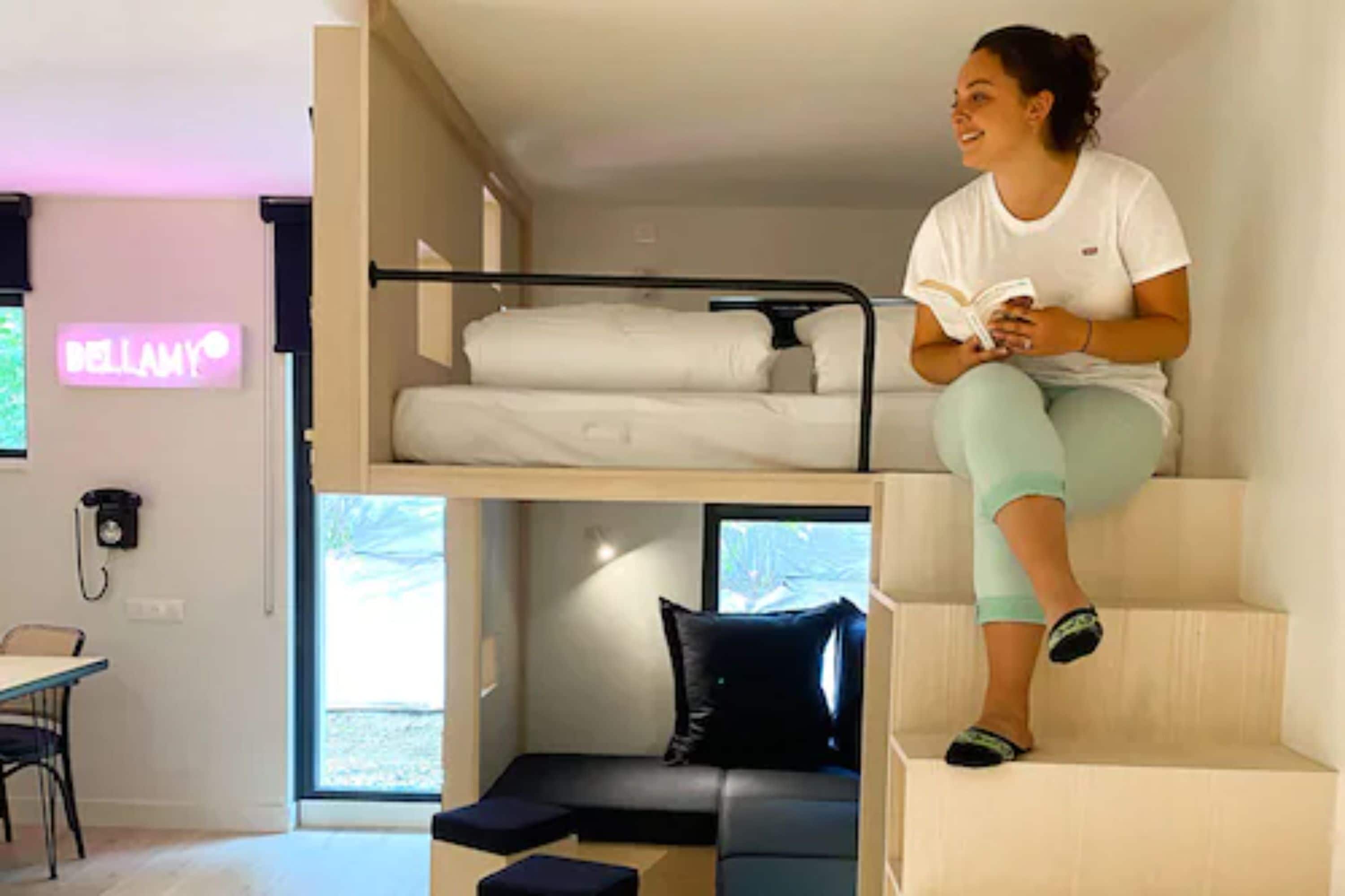 Una habitación moderna con literas, un escritorio y una silla.