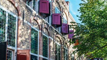Un edificio de ladrillo con ventanas grandes y puertas rojas.