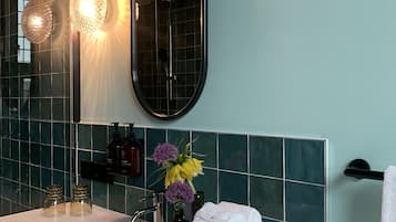 A bathroom with a white sink, a mirror, and a towel rack.