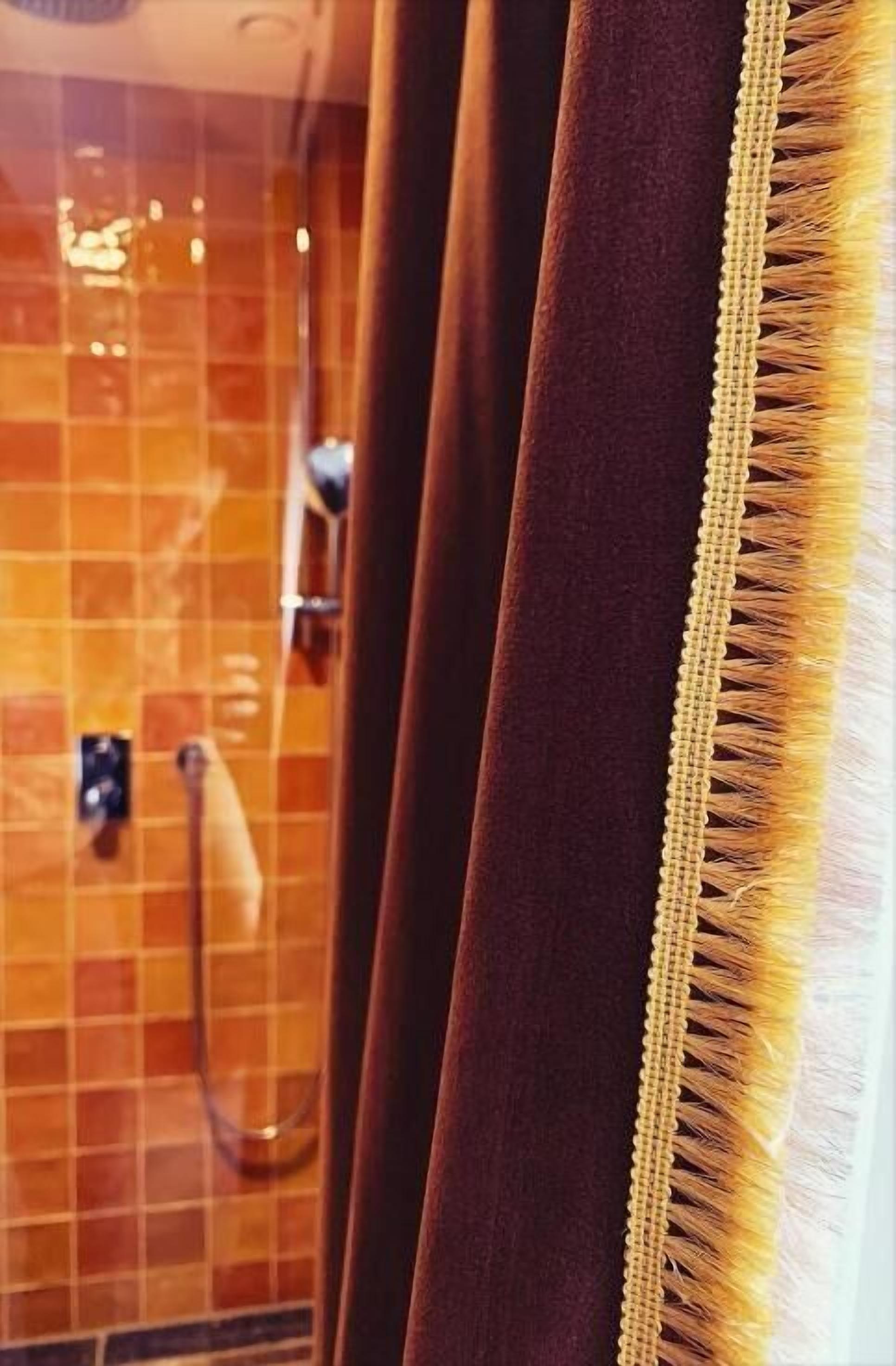 Une salle de bain avec un mur carrelé et un espace douche.
