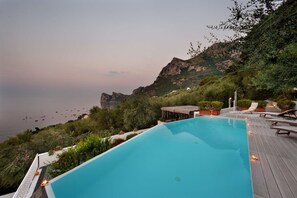 Una piscina con vistas al mar y a las montañas.