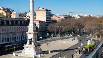 Ein Stadtplatz mit einem Denkmal, Gebäuden und blauem Himmel.