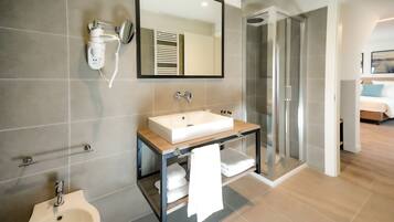 Habitación Deluxe | Baño | Regadera, amenidades de baño gratuitas, secadora de cabello, pantuflas