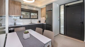 Una cocina moderna con una mesa de comedor, armarios y un refrigerador.