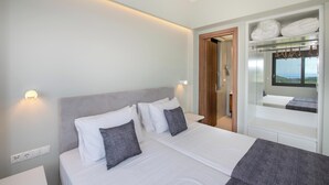 Un dormitorio moderno con una cama grande, mesitas de noche, un armario y vistas al exterior.