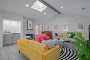 A modern living room with a sofa, chairs, a coffee table, and artwork on the walls. - Vibrant Spacious Home w/ Private Pool and Jacuzzi (Richardson)