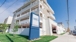 A multi-story hotel with a prominent blue sign reading "IMPALE Suites" and "Shorebreak Resorts".
