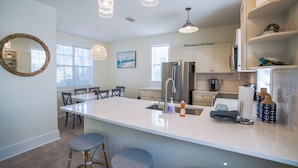 A modern kitchen with a large island, stainless steel appliances, and pendant lighting. - Seagrove 30A Beach Bungalow with Pool and Hot Tub (Santa Rosa Beach)