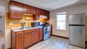 A kitchen with wooden cabinets, a stainless steel refrigerator, a microwave, and an oven. - Candy Bar, Apt #8
One Bedroom with pull out (Hershey)