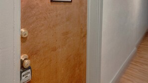A hallway with a wooden door marked with the number 8, a doorbell, and a framed picture on the wall. - Candy Bar, Apt #8
One Bedroom with pull out (Hershey)