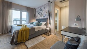 A bedroom with a bed, bedside table, and a view of the outdoors.