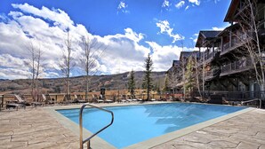 A swimming pool with stone tiles, lounge chairs, and a mountain view. - 4br Ski In/ski Out The Top Of Bachelor Gulch 4 Bedroom Condo by RedAwning (Avon)
