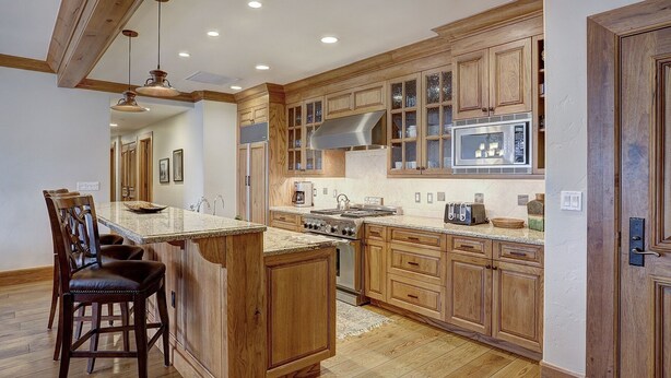 A kitchen with wooden cabinets, a central island, and a stainless steel range hood. - 4br Ski In/ski Out The Top Of Bachelor Gulch 4 Bedroom Condo by RedAwning (Avon)