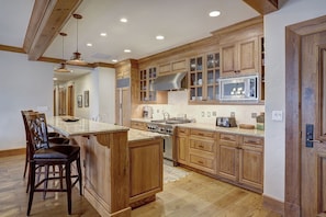 Una cocina amplia con armarios de madera, una isla grande y electrodomésticos modernos.