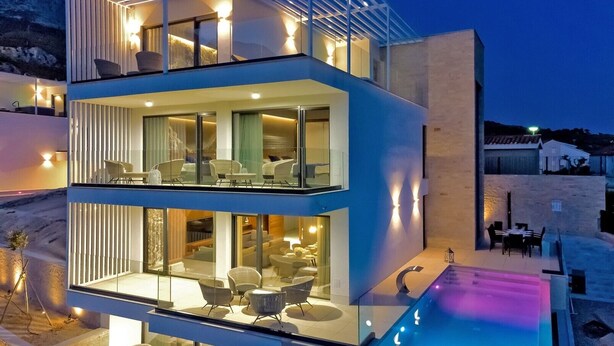 A modern two-story building with balconies, large windows, and outdoor seating areas. - Luxury Villa Delight I – Promajna, Heated Pool (Promajna)