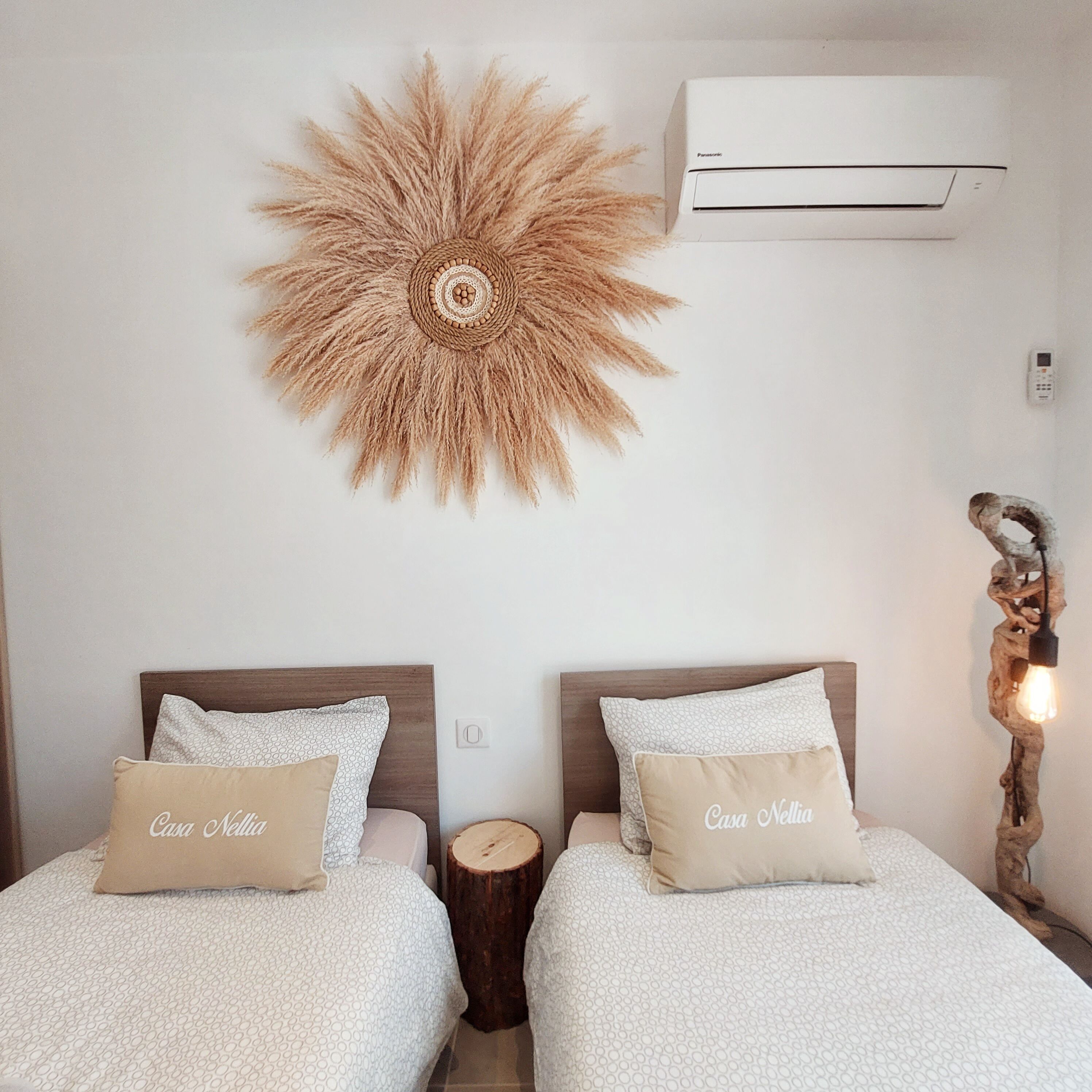 Ein Zimmer mit zwei Betten, einer Wandklimaanlage und einem Wandbild.