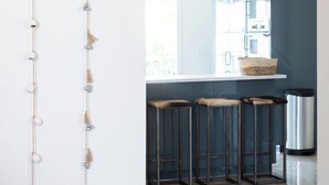 A modern kitchen with a bar area, featuring a hanging light fixture and a white countertop. - Home2Book Stunning Design House Arafo (Arafo)