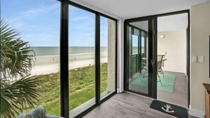 A room with large glass doors leading to a balcony with a view of the beach. - Oceanfront, Pool, Beach Gear, Tennis, Smart TVs (St. Augustine)
