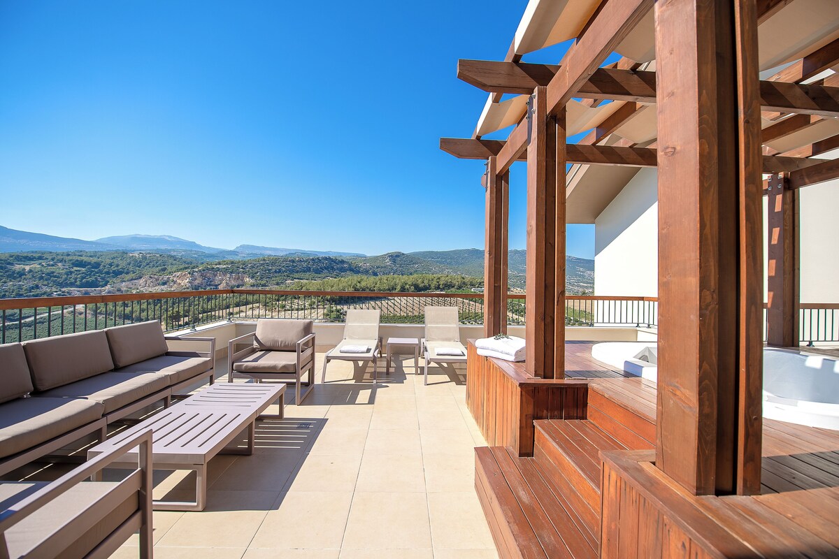 Une terrasse dotée d’une plateforme en bois, de sièges extérieurs et offrant une vue sur le paysage.