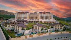 A hotel with multiple buildings, a swimming pool, and a landscaped garden.