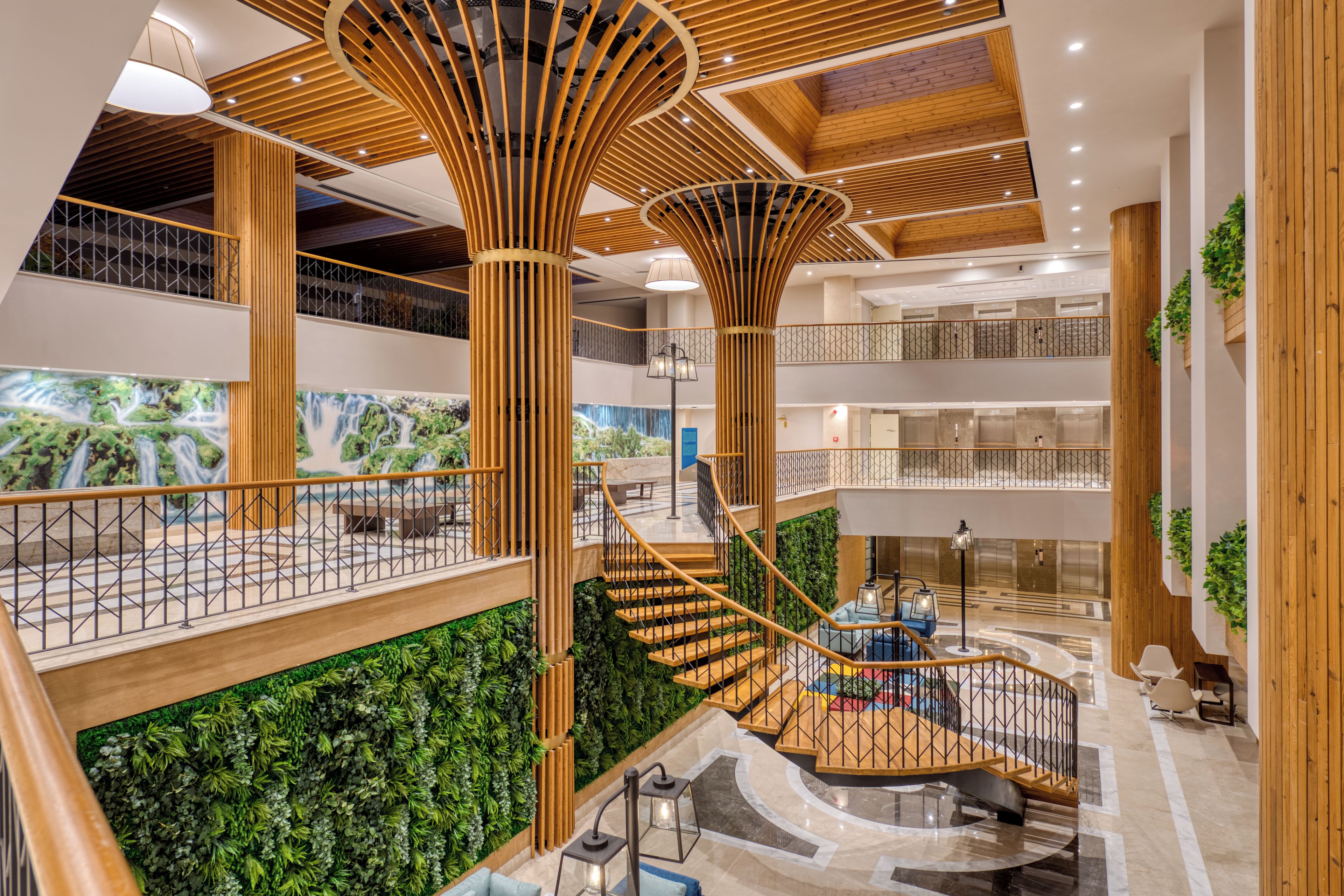 A multi-level atrium with wooden columns, a central spiral staircase, and green wall gardens.