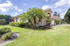 A single-story house with a beige exterior, a palm tree in the front yard, and a clear blue sky. - 514-Fabulous 4 Bed in Orange Tree w/ Private Pool, Deck and Spa (Clermont)