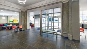 Un hall d’entrée spacieux doté d’un espace salon central, d’une entrée avec porte vitrée et d’un design de plafond moderne.