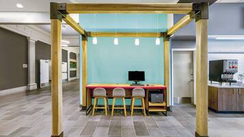 A modern workspace with a wooden frame, a teal wall, and a desk with three chairs.