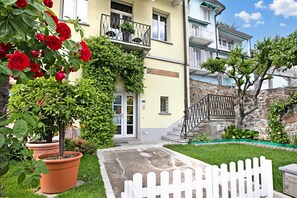 A building with a stone staircase, a white picket fence, and a sign reading 'CANTINE BORGENOS.' - Casa Tame - Pieds Dans L'eau (Melide)