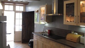 Eine Küche mit Holzausstattung, einer schwarzen Arbeitsplatte und einem eingebauten Backofen.