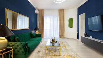 Apartamento Deluxe | Zona de estar | Smart TV de 139 cm con canales digitales, una televisión