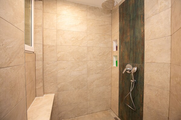 Eine Dusche mit Handbrause und Wandarmatur.
