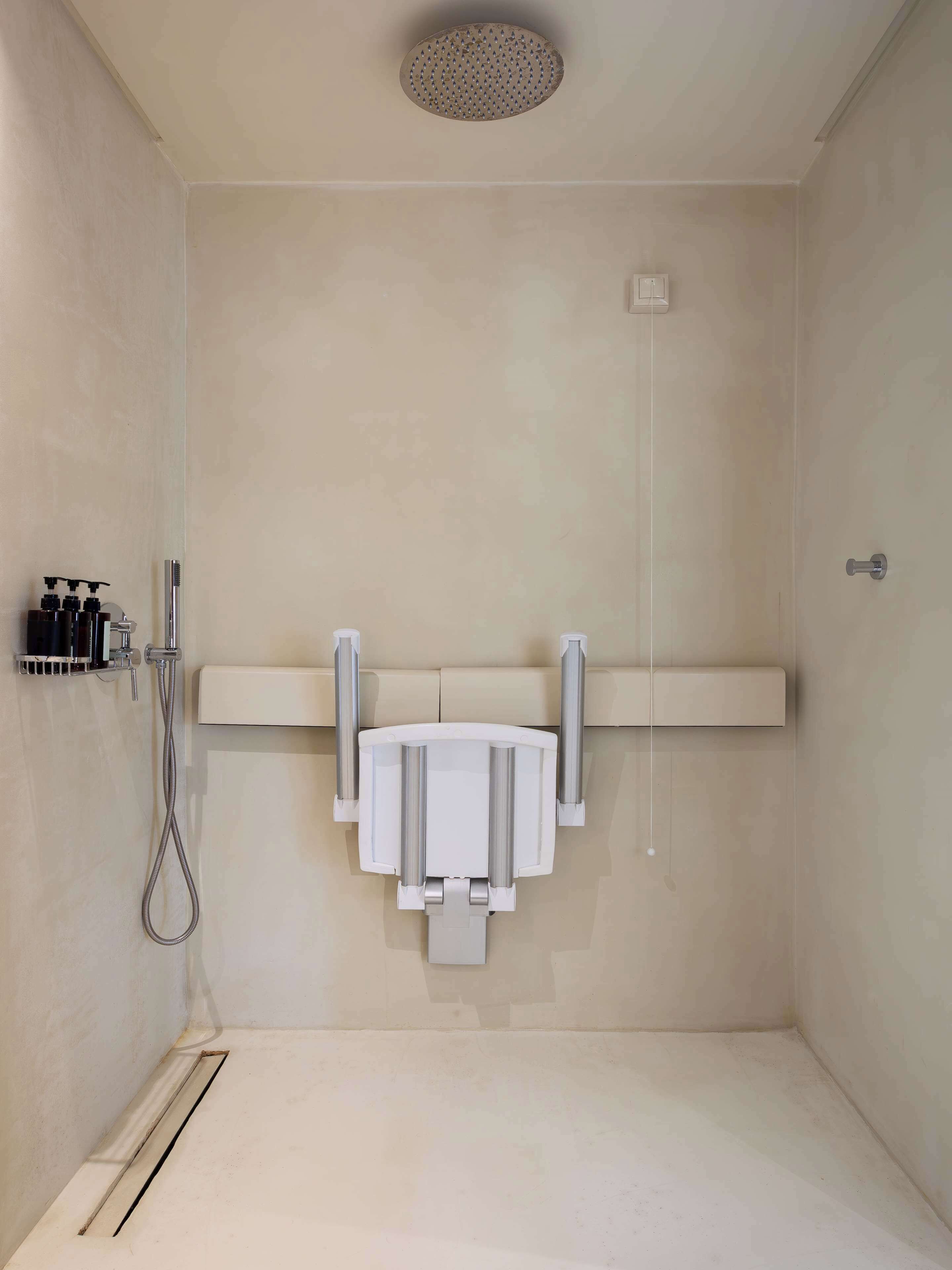 Ein modernes Duschbad mit Duschbrause, Bedienfeld an der Wand und Handtuchhalter.
