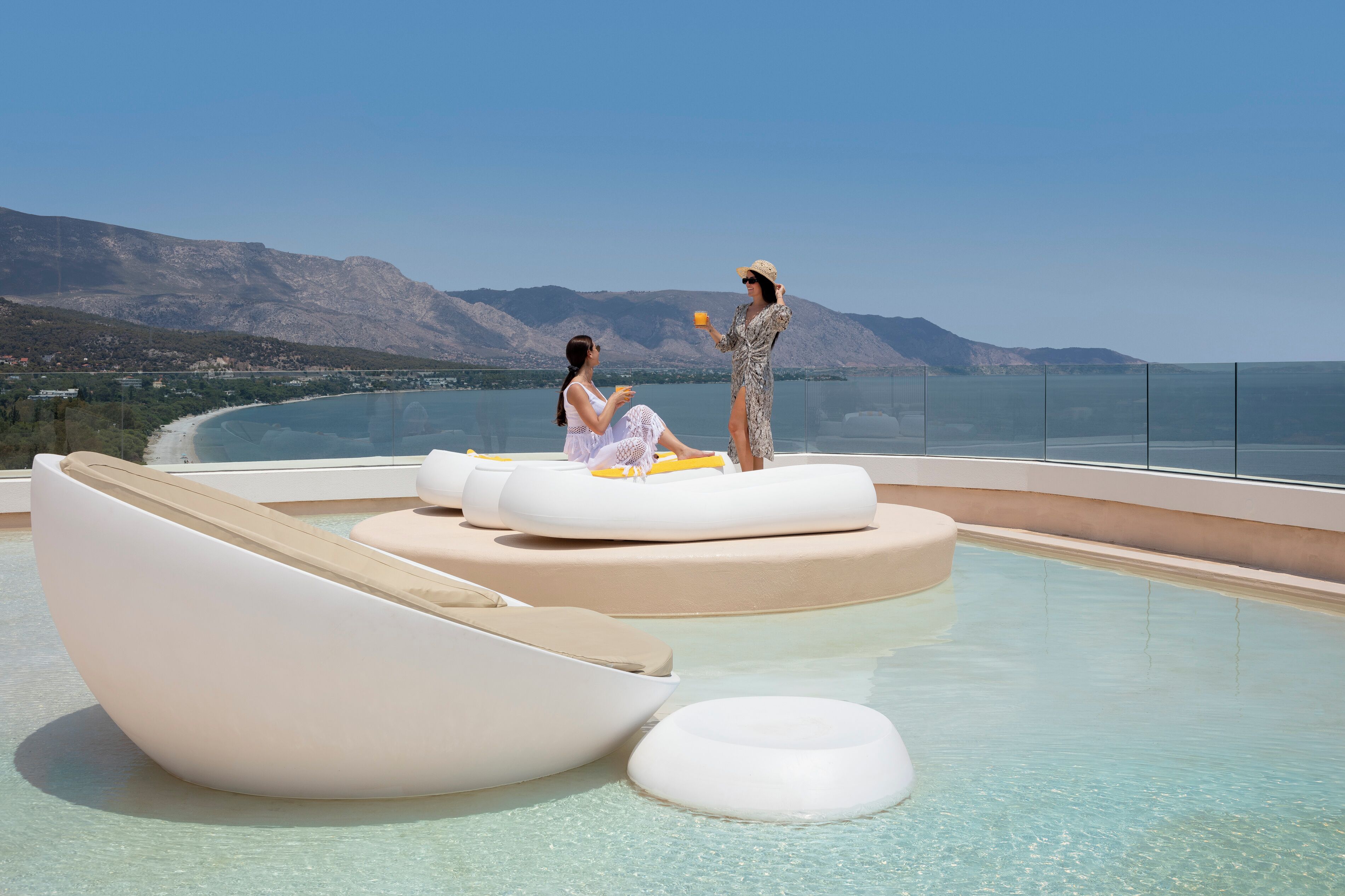 A pool area with modern loungers and a clear view of the surrounding landscape.