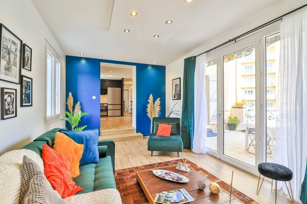 Una sala de estar moderna con un sofá verde, una mesa de centro y vistas a un balcón.