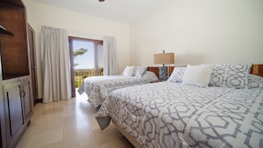 A hotel room with two beds, a wooden cabinet, a nightstand, and a view of the outdoors.